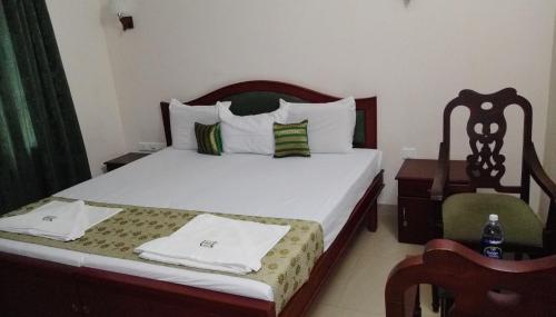 Elim Homestay Fort Kochi في كوتشي: غرفة نوم بسرير وكرسي في غرفة