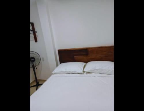 a bed with white sheets and pillows in a room at KOKOA GARDEN INN in San Vicente de Chucurí