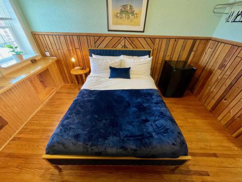 a bedroom with a bed with a blue comforter at Skyline Village Inn in Spruce Pine