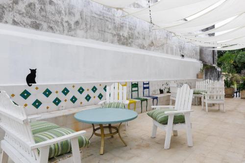 a cafe with chairs and a table and a cat on the wall at PLENO CENTRO MERIDA ESTUDIO3 CASA PAXI in Mérida