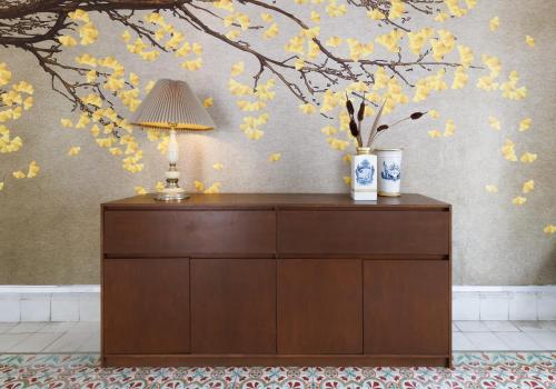 a dresser with a lamp and flowers on a wall at PLENO CENTRO MERIDA ESTUDIO3 CASA PAXI in Mérida