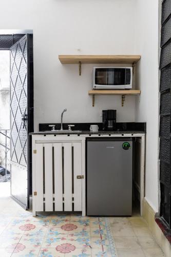 a kitchen with a sink and a microwave at PLENO CENTRO MERIDA ESTUDIO3 CASA PAXI in Mérida