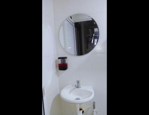 a bathroom with a sink and a mirror at KOKOA GARDEN INN in San Vicente de Chucurí
