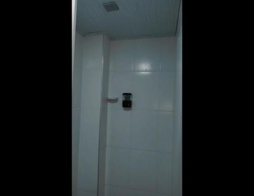 a white shower with a door in a room at KOKOA GARDEN INN in San Vicente de Chucurí