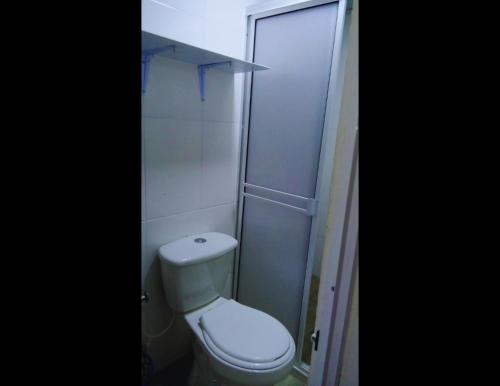 a small bathroom with a toilet and a shower at KOKOA GARDEN INN in San Vicente de Chucurí