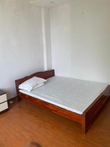 ein Bett mit einem Holzrahmen in einem Zimmer in der Unterkunft Hotel Hải Vân 2 in Diện Biên Phủ