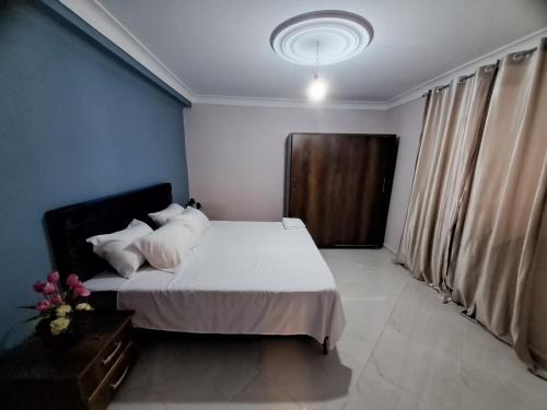 a bedroom with a bed with white sheets and pillows at Villa belle vue in Boumaʼchouk