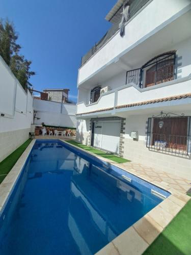 a swimming pool in front of a house at Villa belle vue in Boumaʼchouk
