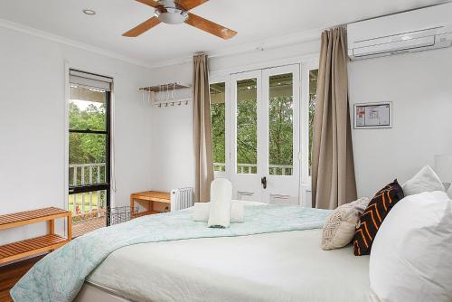 a bedroom with a bed with a ceiling fan at Wild Rose Cottage Kiaroo Estate, Kangaroo Valley in Kangaroo Valley