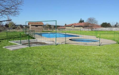 una piscina en un campo con una valla en Cabañas el mirador de Rio Claro en Río Claro