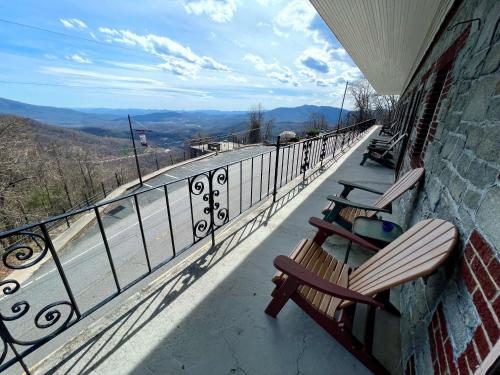 two benches sitting on a balcony looking over the water at Skyline Village Inn in Spruce Pine