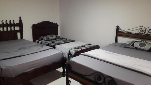 eine Gruppe von 3 Betten in einem Zimmer in der Unterkunft Casa rural o chalet in Santa Rosa de Cabal