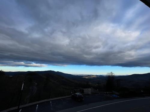 a car driving down a road under a cloudy sky at Skyline Village Inn in Spruce Pine