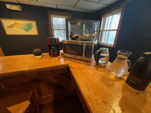 a kitchen counter with a microwave on a wooden table at Skyline Village Inn in Spruce Pine