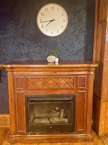 a clock on a wall above a fireplace with a fireplace at Skyline Village Inn in Spruce Pine