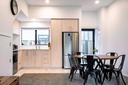 a kitchen and dining room with a table and chairs at Spacious CBD 3BR- Walk to Hagley, CBD, Hosp, & Oval in Christchurch