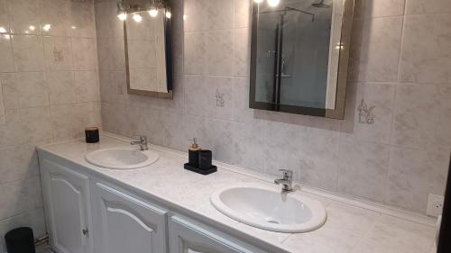 ein Badezimmer mit zwei Waschbecken und zwei Spiegeln in der Unterkunft Le Paris Normand in Gouchaupré