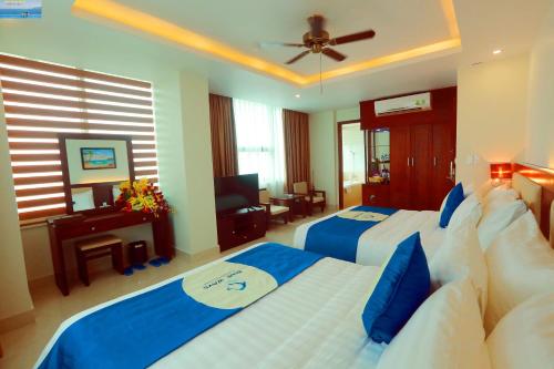 a bedroom with two beds with blue and white sheets at Blue Wave Hotel in Cửa Lò