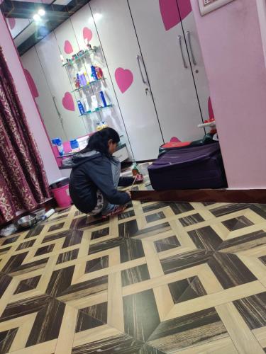 una mujer sentada en el suelo en una habitación en Poonam Palace jodhpur, en Jodhpur