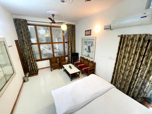 1 dormitorio con cama, sofá y mesa en Poonam Palace jodhpur, en Jodhpur
