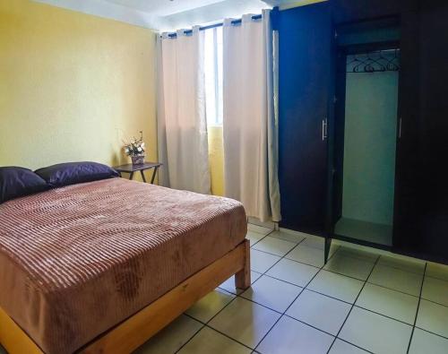 1 dormitorio con cama, ventana y puerta en Cómoda Casa 3Hab: Piscina, Seguridad, Parking en Emiliano Zapata