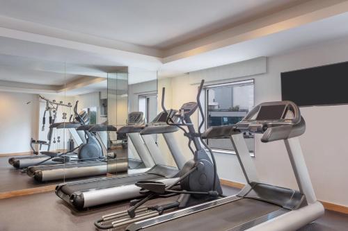 a gym with several cardio machines and a flat screen tv at Four Points by Sheraton Vadodara in Vadodara