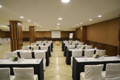 a banquet hall with white tables and white chairs at Four Points by Sheraton Vadodara in Vadodara