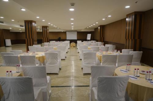 a banquet hall with white tables and white chairs at Four Points by Sheraton Vadodara in Vadodara