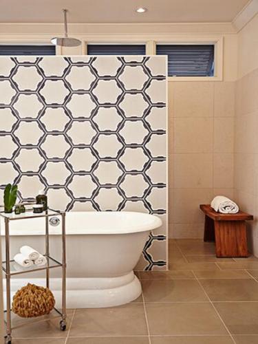 a bathroom with a white tub and a shower at The Island House in Nassau