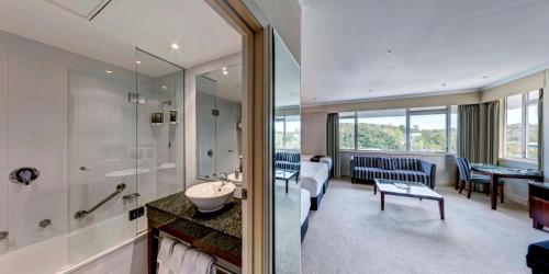 a bathroom with a sink and a shower and a room at Rutherford Hotel Nelson - A Heritage Hotel in Nelson