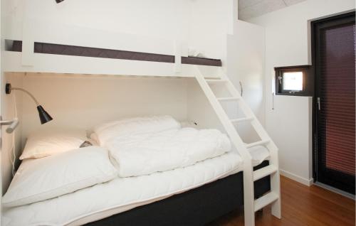 ein weißes Etagenbett mit weißen Kissen darauf in der Unterkunft Awesome Home In Haderslev With Kitchen in Kelstrup