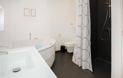 ein weißes Bad mit einer Badewanne und einem WC in der Unterkunft Awesome Home In Haderslev With Kitchen in Kelstrup