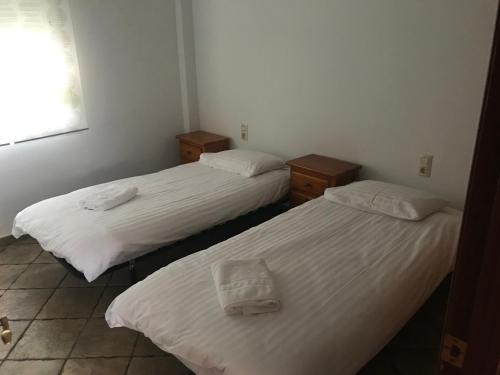 two beds in a room with white sheets at Ebro Fishing in Mequinenza