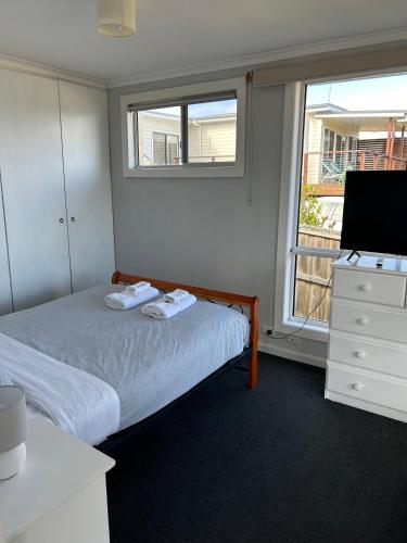 a bedroom with a bed and a dresser and a window at Island Escapes in Alonnah
