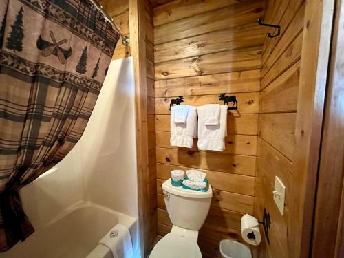 a bathroom with a toilet and a bath tub at Badlands Frontier Cabins in Wall