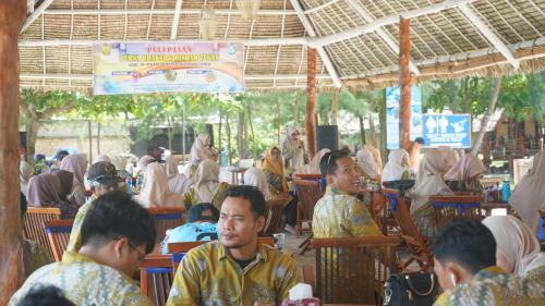 a group of people sitting at tables in a restaurant at Madu Tiga Beach and Resort in Tanjung Pinang 