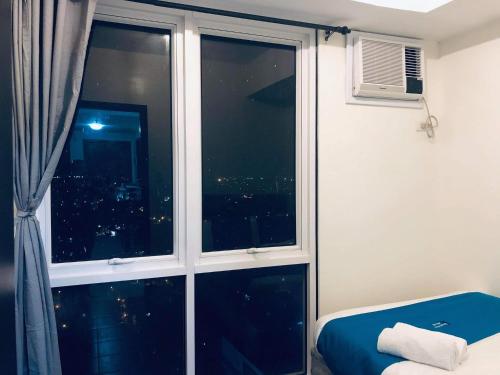 a room with a window with a view of a city at Kasara Urban Resort 1BR Condo in Manila