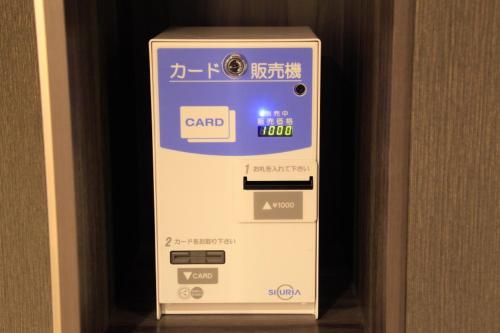 a vending machine with a card on top of it at Hotel Sunroute Ginza in Tokyo