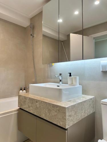 y baño con lavabo blanco y bañera. en Buyan’s apartment, en Ulán Bator