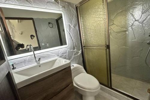 La salle de bains est pourvue d'un lavabo, de toilettes et d'une douche. dans l'établissement Villa Diana, Condominio Oasis, à Guayabal de Síquima