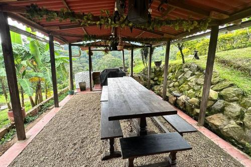 a wooden picnic table sitting under a pavilion at Villa Diana, Condominio Oasis in Guayabal de Síquima