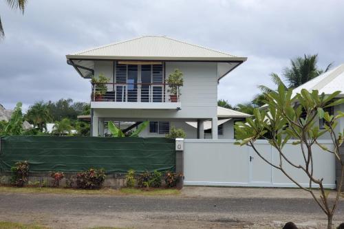 a house with a white fence in front of it at Faré Vaihere in Haapiti