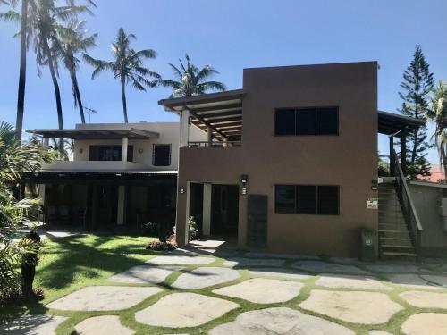 a house with palm trees in front of it at Luxury in Wailoaloa in Nadi