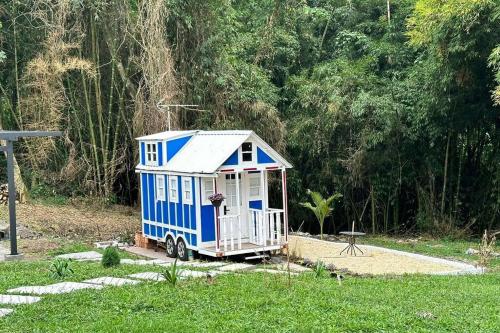 a small blue and white tiny house in a yard at Tiny House On Wheels - Guayabal de Siquima in Guayabal de Síquima