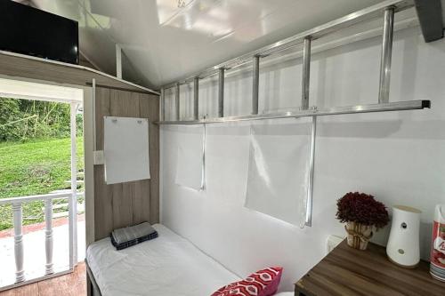 een kleine caravan met een bed en een raam bij Tiny House On Wheels - Guayabal de Siquima in Guayabal de Síquima