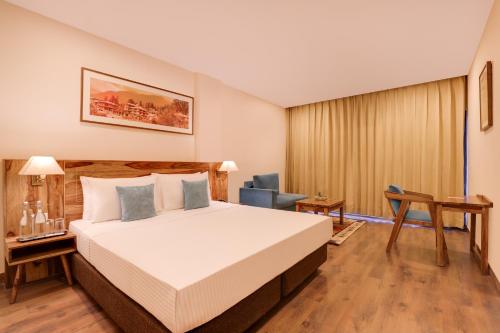 a hotel room with a bed and a desk at Lemon Tree Hotel, Kasauli in Kasauli