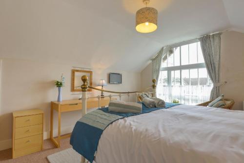 a bedroom with a large bed and a window at Regatta Cottage in Feock