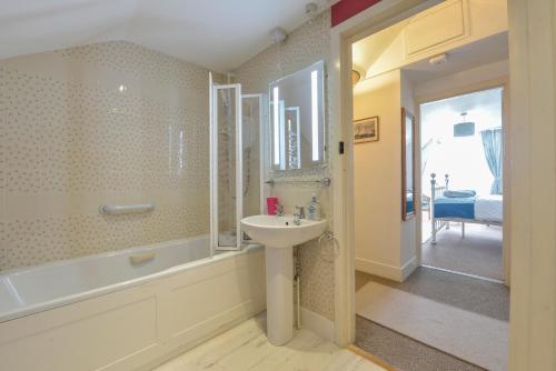 a bathroom with a sink and a bath tub and a sink at Regatta Cottage in Feock