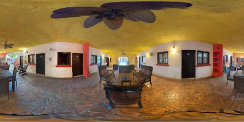 a living room with a ceiling fan and a table at Hostal ROCA INN in Mazatlán