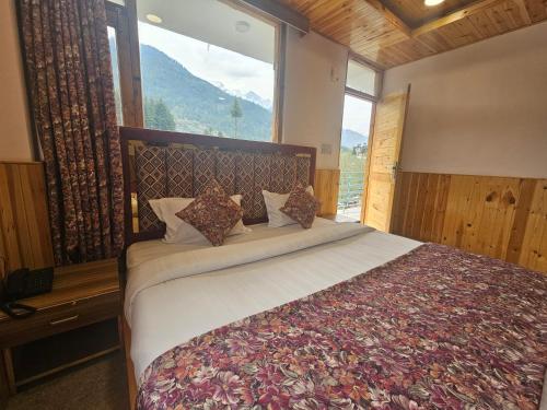 um quarto com uma cama grande e uma janela grande em Hotel Old Manali - The Best Riverside Boutique Stay with Balcony and Mountain Views em Manali